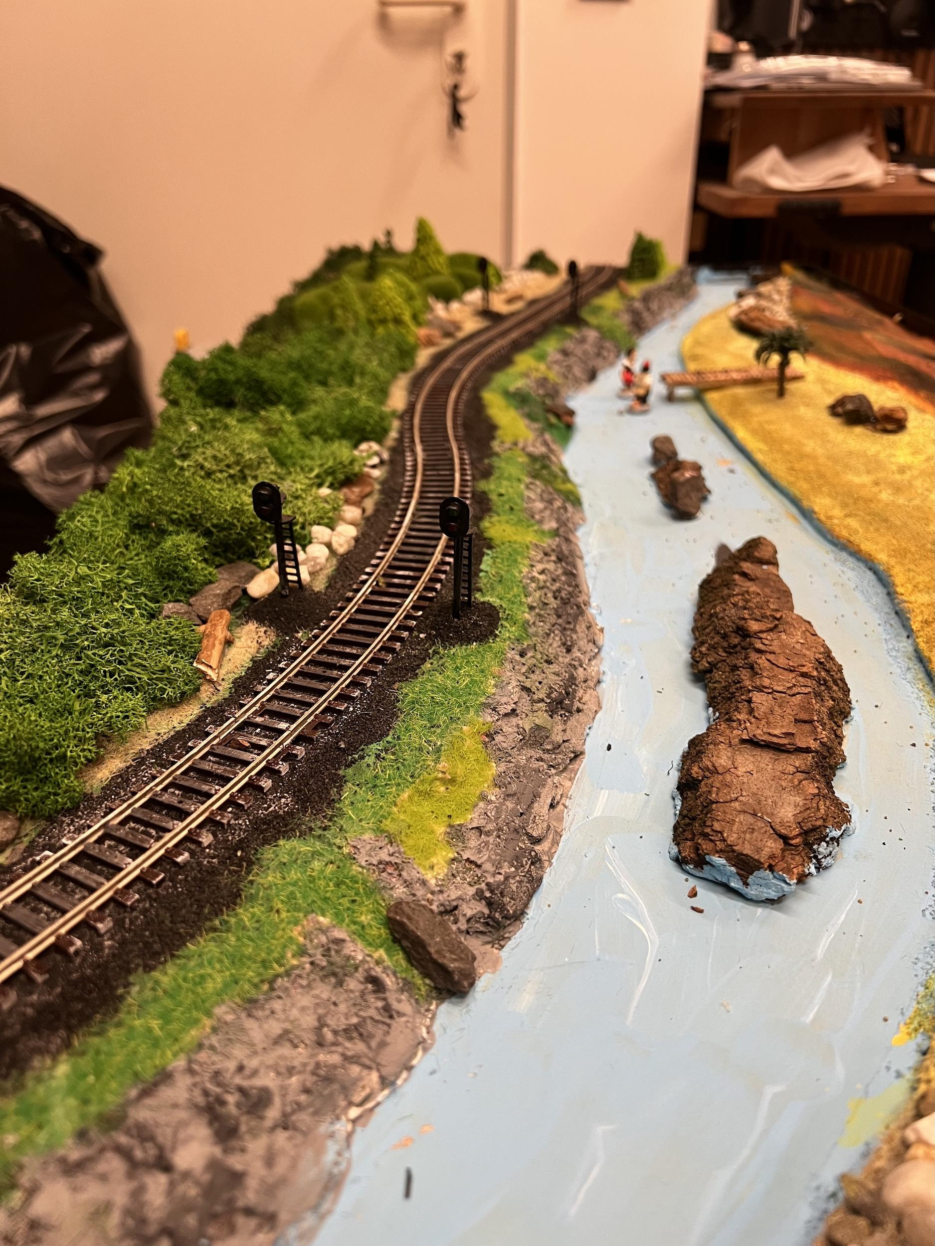 Насыпал травки и положил коры из леса. Покрасил «берега» как будто это камни (никто не узнает, что это просто пенопласт)